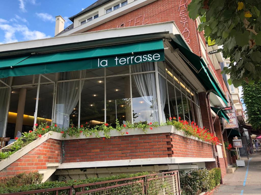 リジューにあるLogis Terrasse Hôtelのテラザを読む看板のあるレストラン