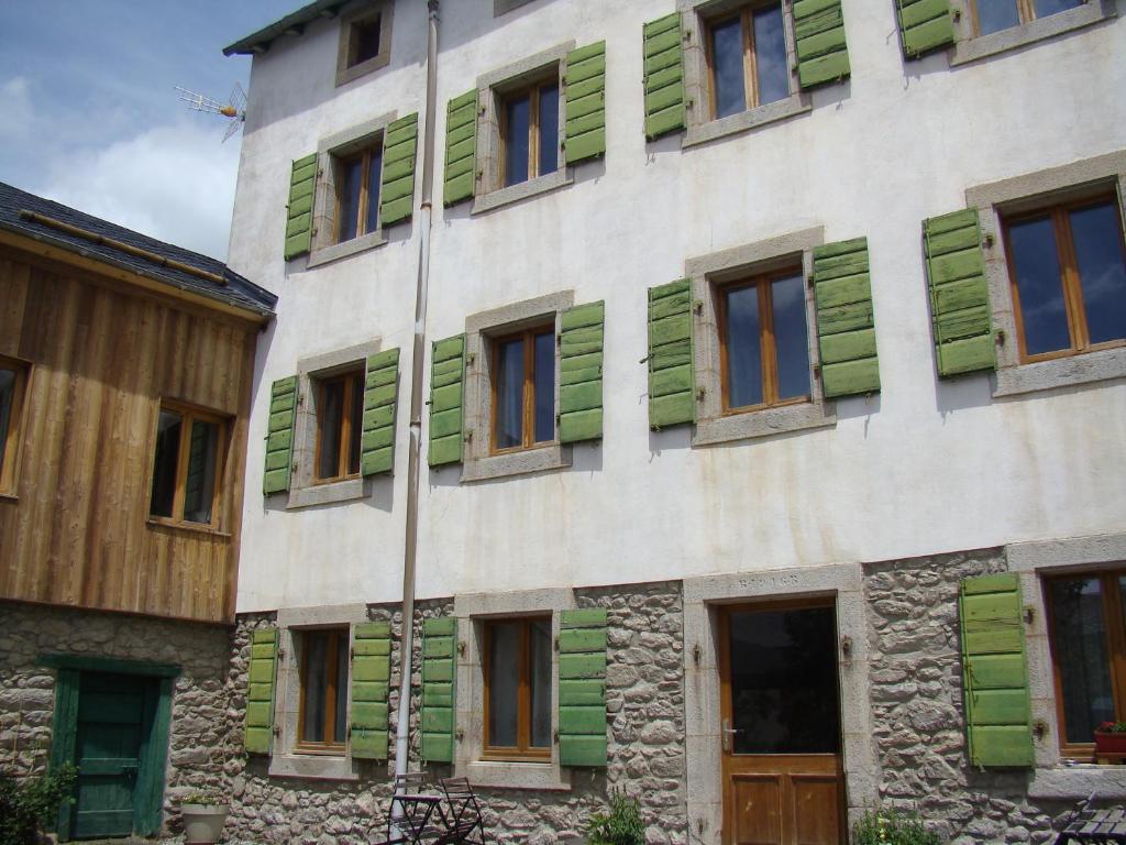 - un bâtiment doté de fenêtres vertes et blanches dans l'établissement Chez Christine Et Fabrice, à Font-Romeu-Odeillo-Via