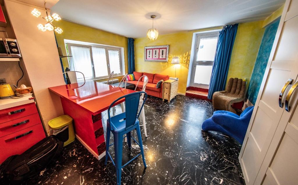 加爾達湖濱的住宿－思麗維公寓，客厅配有红色的办公桌和沙发。