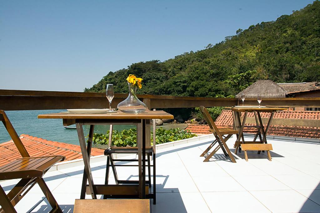 トリンダーデにあるTrindade Hospeda -Casa 1- Você a Varanda e o Marの屋上にテーブルと椅子が2脚あるパティオ