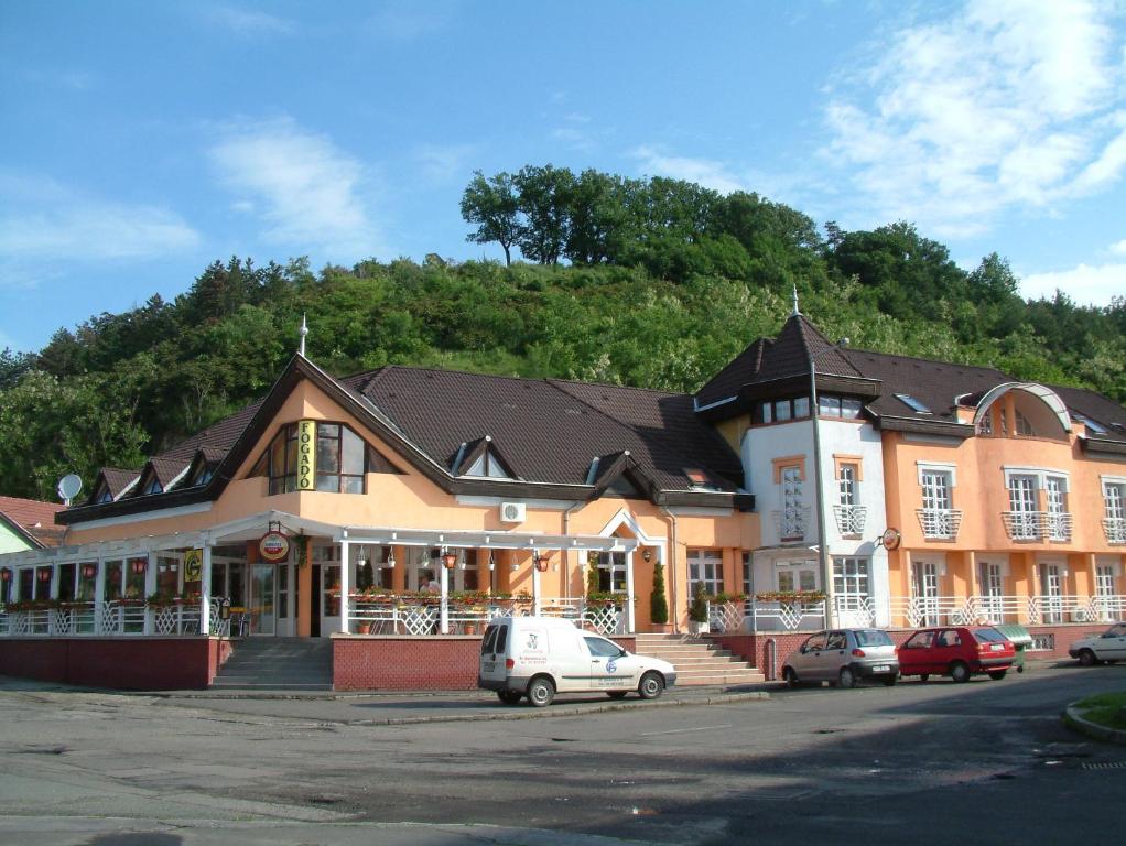 a large building with cars parked in front of it at Galcsik Fogadó in Salgótarján