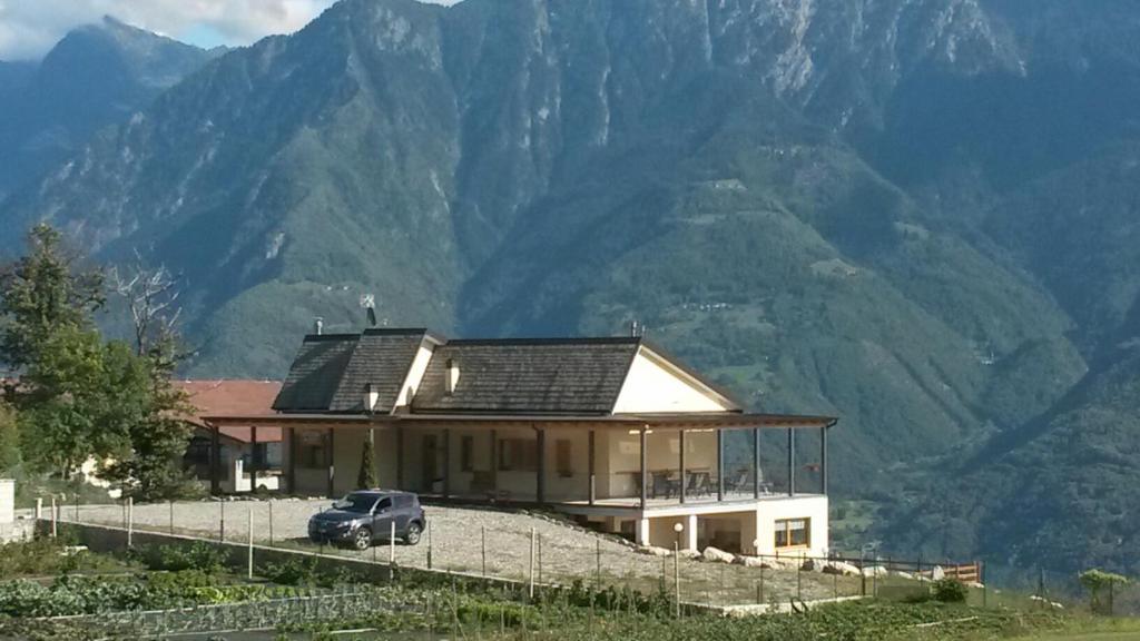 um carro estacionado em frente a uma casa com montanhas em Agriturismo da Ysy em Civo