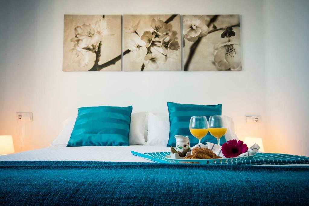 Holidays2Malaga Heredia 3 bedroom opposite Malaga Port في مالقة: سرير مع صينية طعام وكأسين من النبيذ