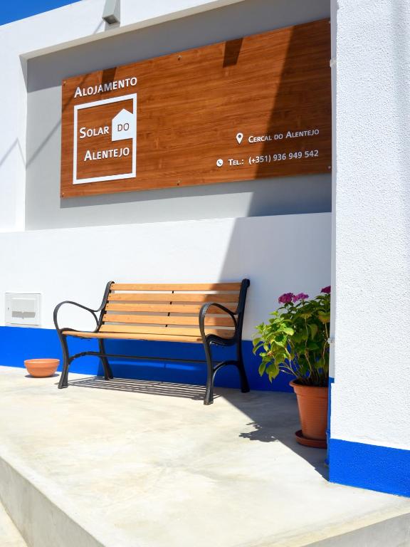 a bench sitting under a sign on a wall at Solar do Alentejo in Cercal