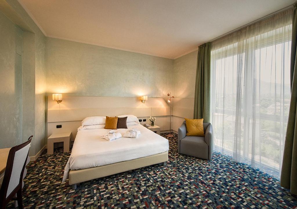 a hotel room with a large bed and a large window at Hotel Ovidius in Sulmona