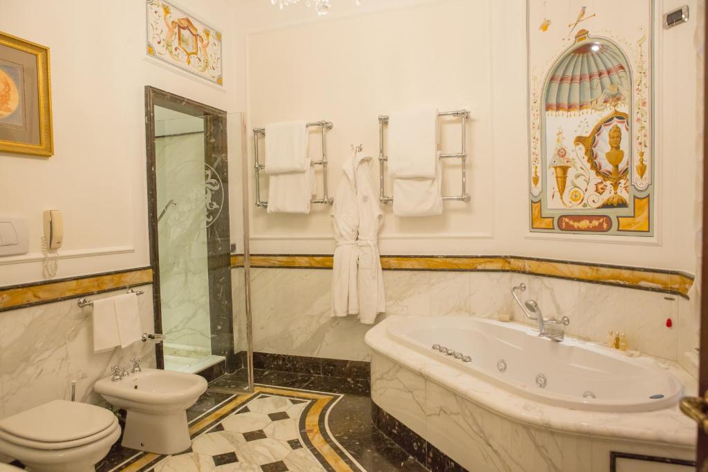 a bathroom with a tub and a toilet and a sink at Grand Hotel Majestic gia' Baglioni in Bologna