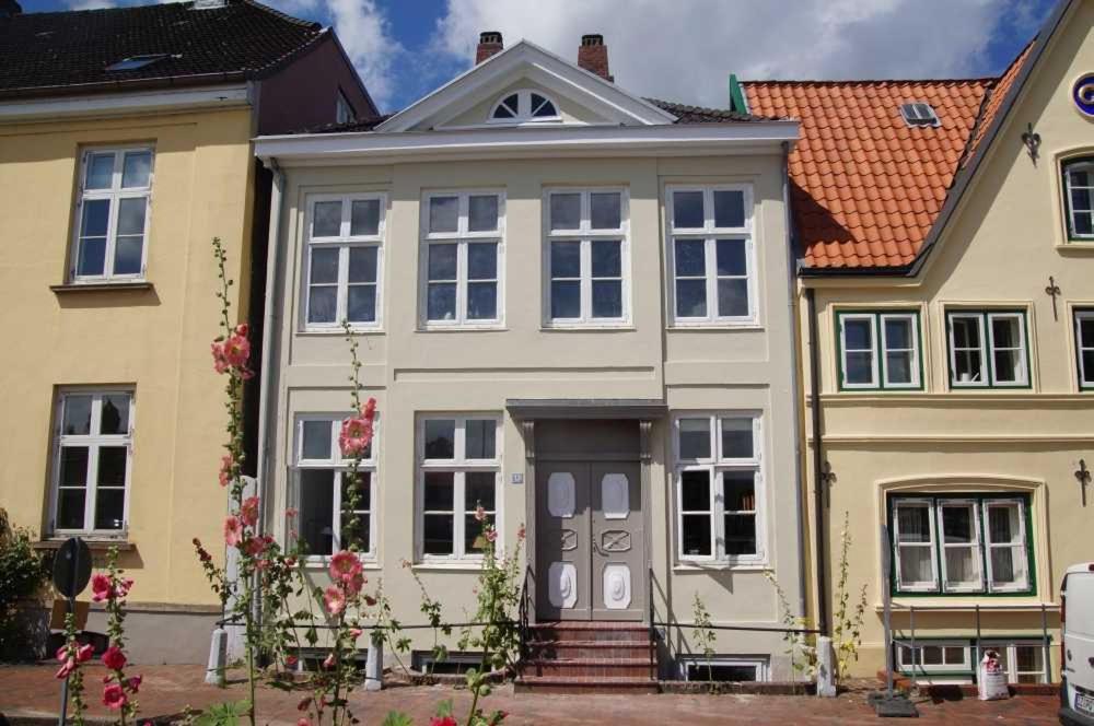 een groot huis met een grijze deur en geel bij Am Hafen 13 in Glückstadt