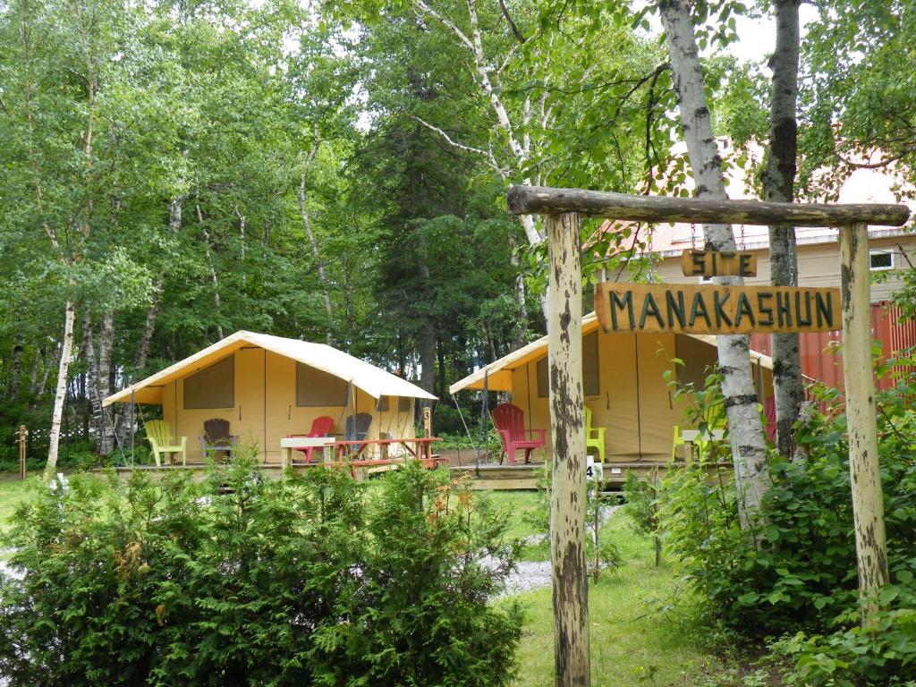 una casa gialla con un cartello davanti di Prêts-à-camper Camping Tadoussac a Tadoussac