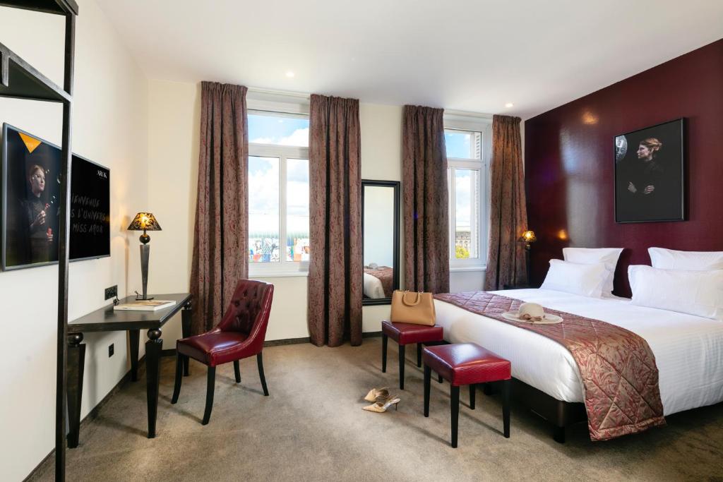 ein Hotelzimmer mit einem Bett, einem Schreibtisch und Stühlen in der Unterkunft Hotel Arok in Straßburg