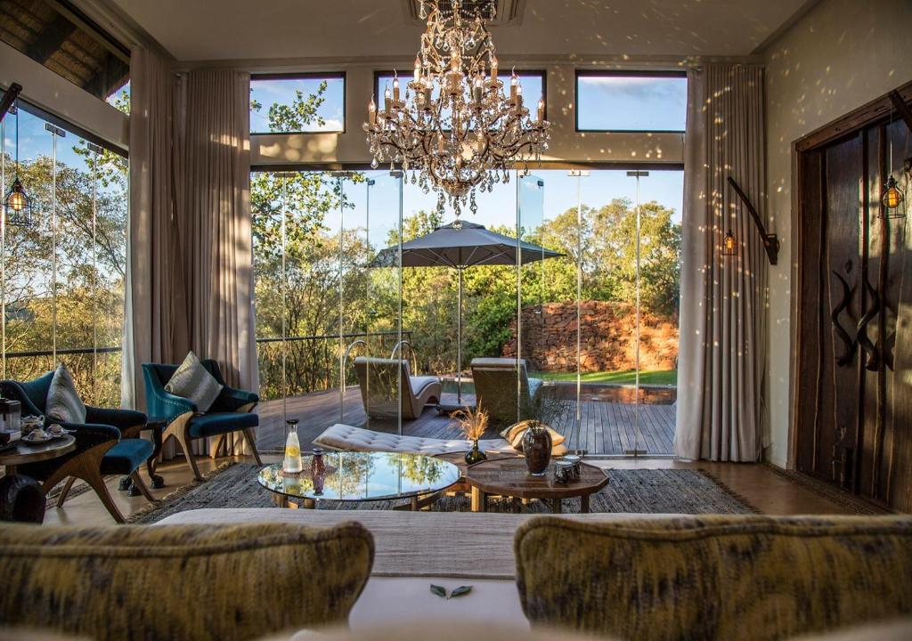 a living room with a chandelier and a large window at Moledi Gorge in Rustenburg