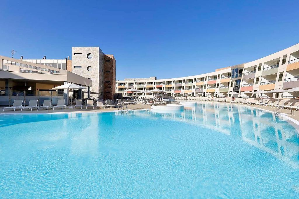 
a large swimming pool in a hotel room at Eurostars Las Salinas in Caleta De Fuste
