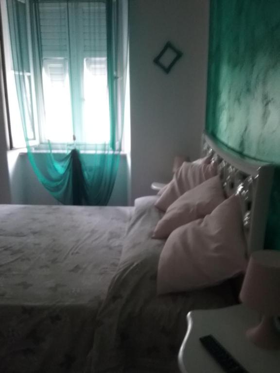 Schlafzimmer mit einem weißen Bett und einem Fenster in der Unterkunft La casa di Circe in Triest