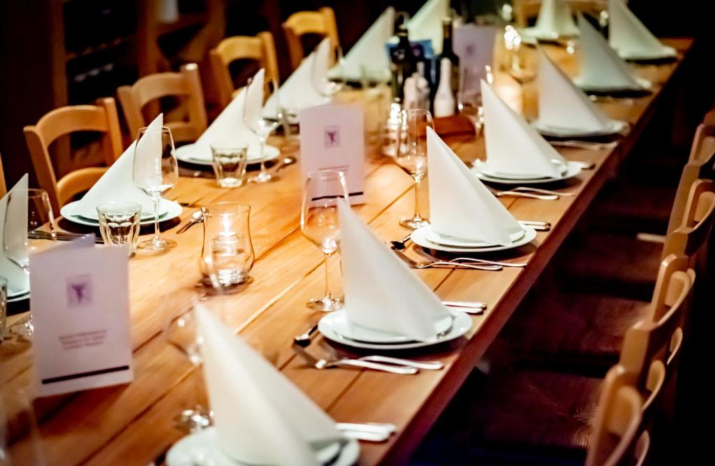 a long wooden table with white napkins and wine glasses at XII Apostel Albergo in Cologne