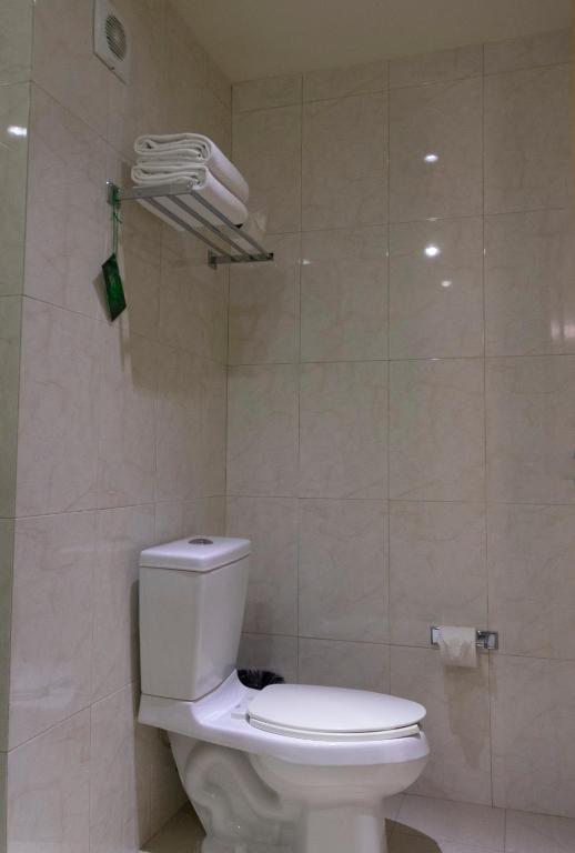 a bathroom with a white toilet in a room at Hotel Aeropuerto Los Cabos in San José del Cabo