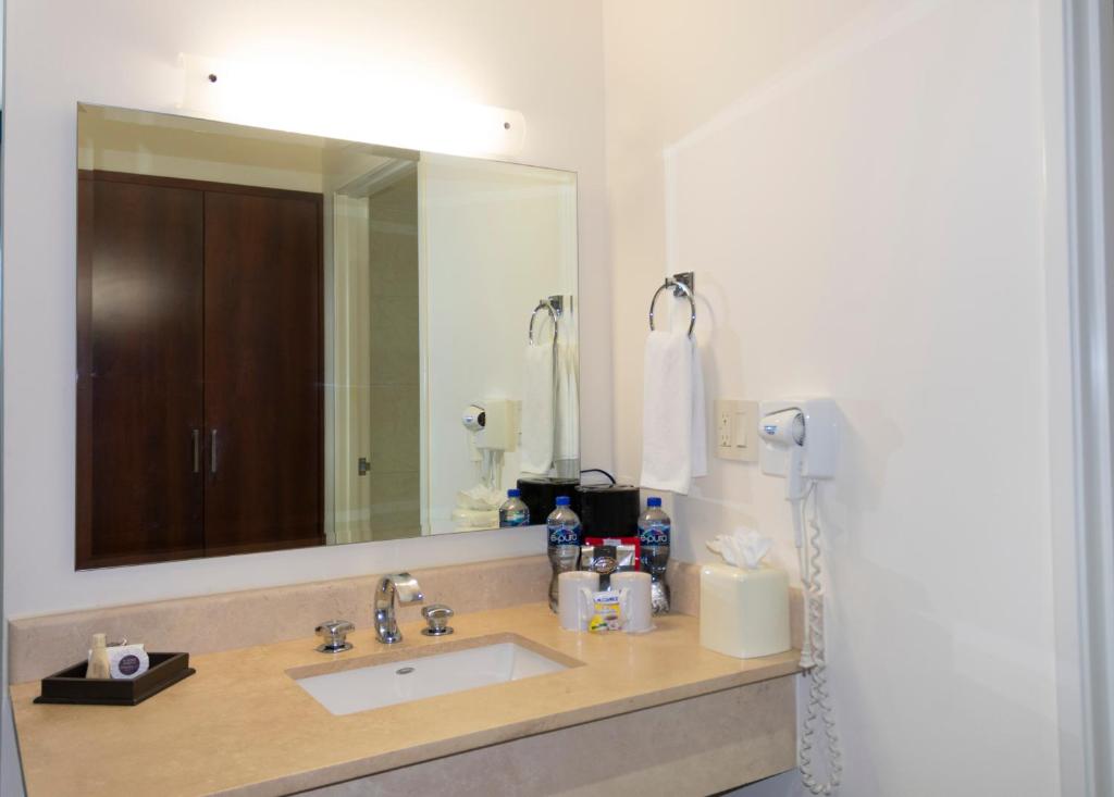 a bathroom with a sink and a large mirror at Hotel Aeropuerto Los Cabos in San José del Cabo