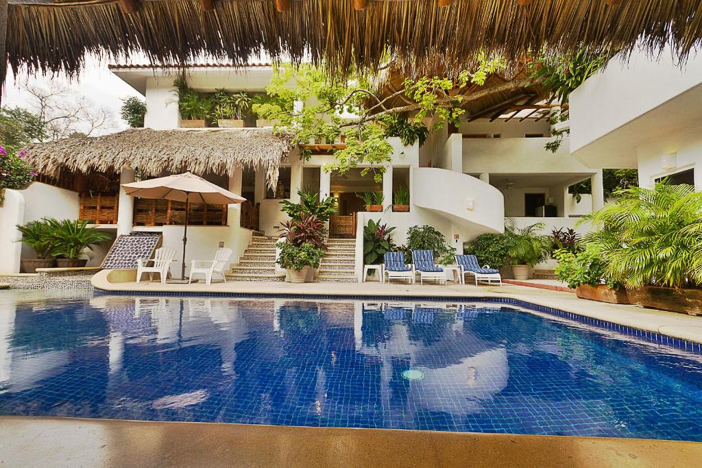a swimming pool in front of a hotel at Villas Naomi in Zihuatanejo
