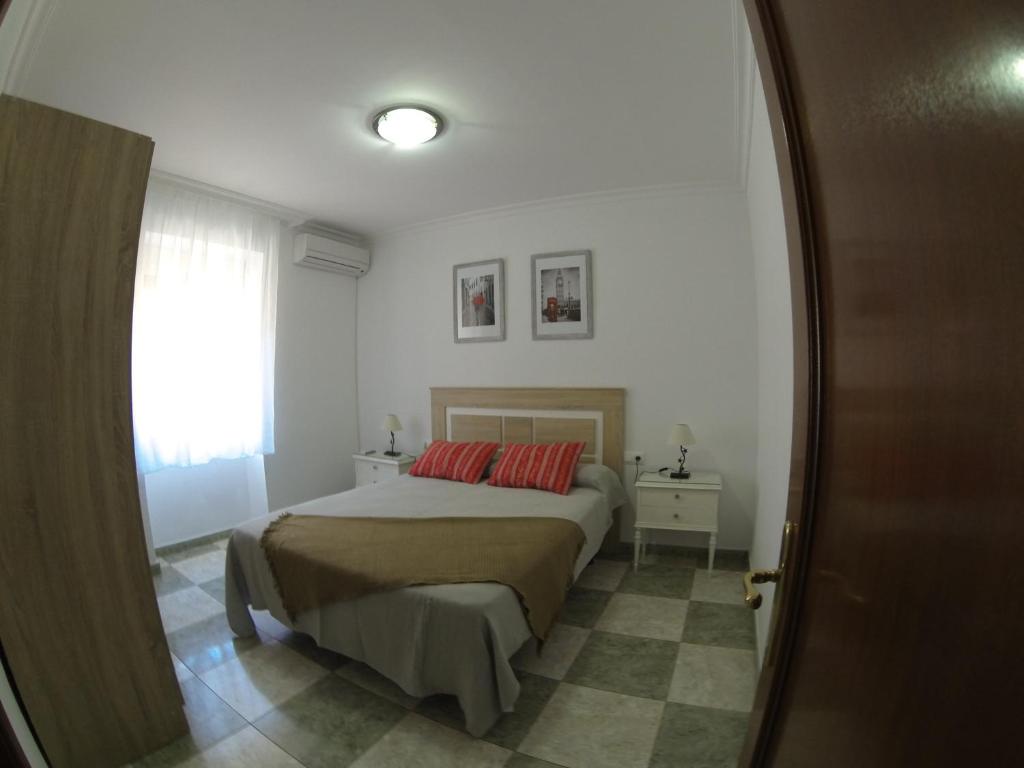 a bedroom with a bed with two red pillows at ALTILLO 25 GARAJE Y WIFI GRATIS in Córdoba