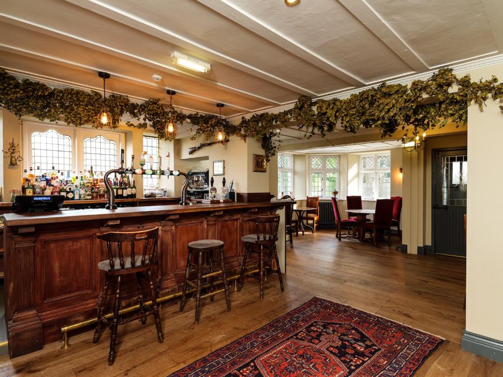 eine Bar in einem Zimmer mit einem Tisch und Stühlen in der Unterkunft The Wheatsheaf at Beetham in Sandside