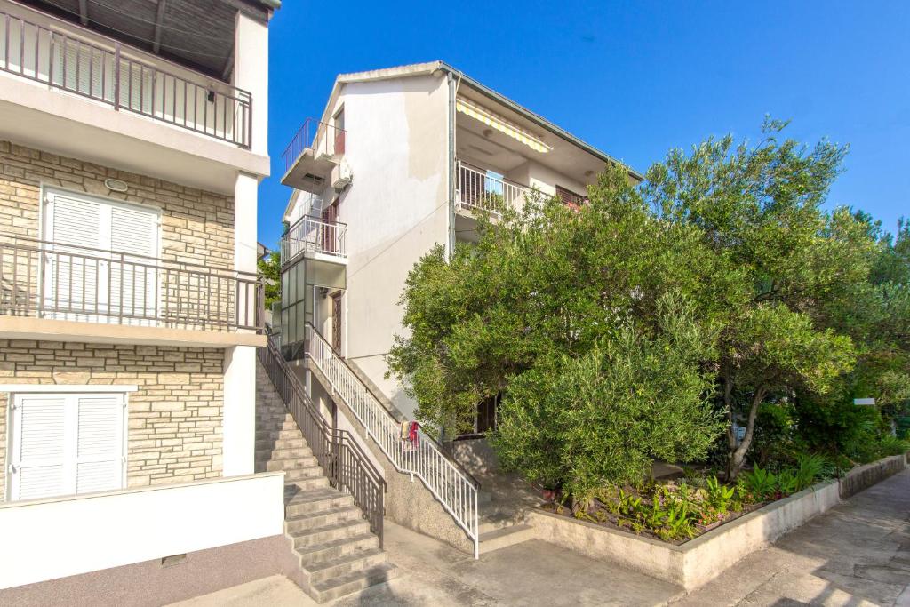 an apartment building with a tree in front of it at Apartments Ivan in Vodice