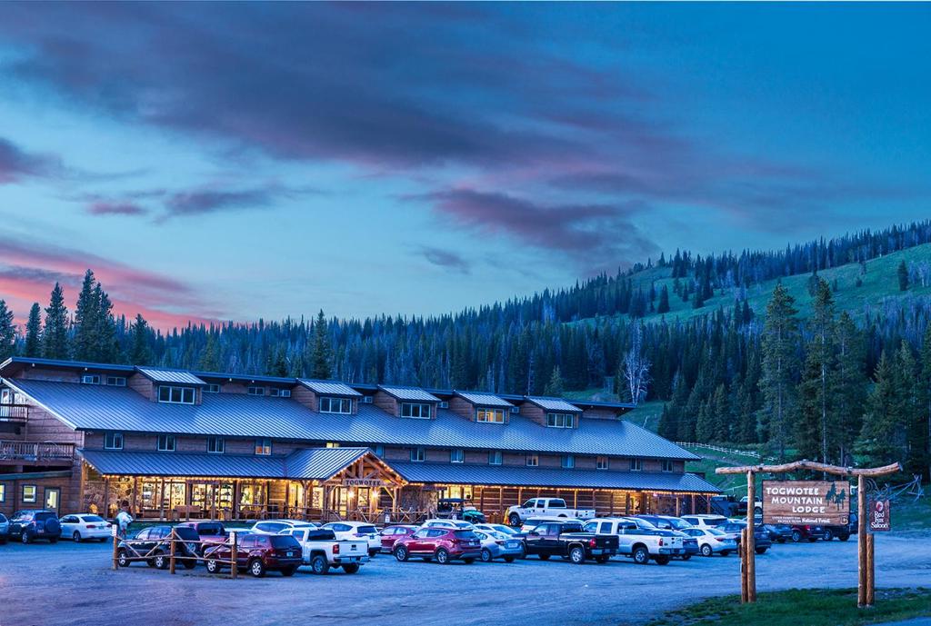 a large building with cars parked in a parking lot at Togwotee Mountain Lodge in Moran