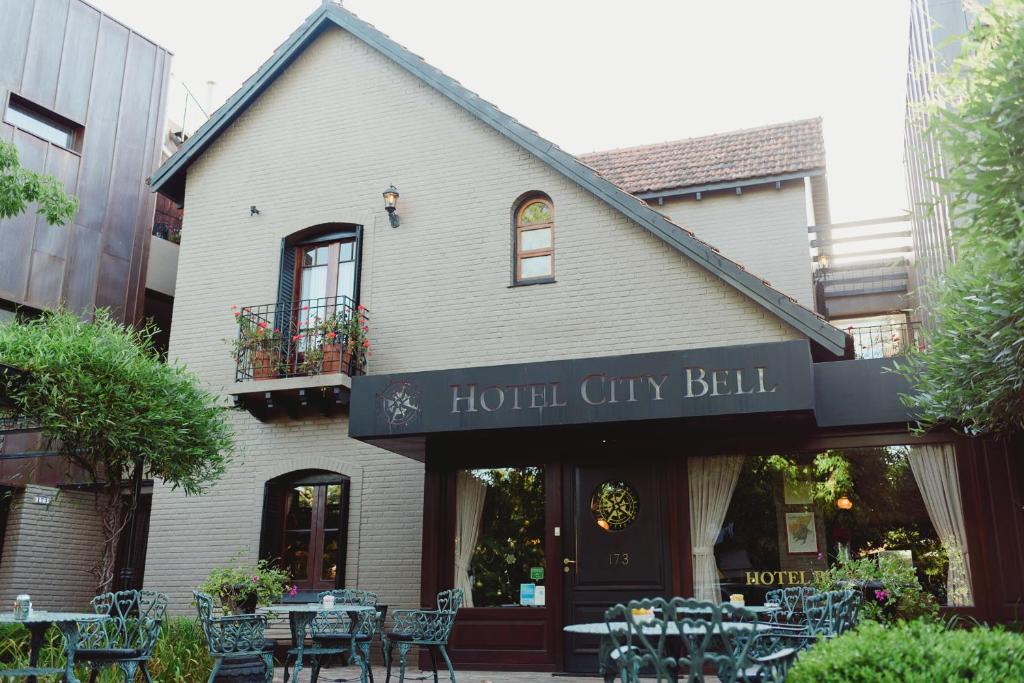 a restaurant with tables and chairs in front of a building at Hotel City Bell in La Plata