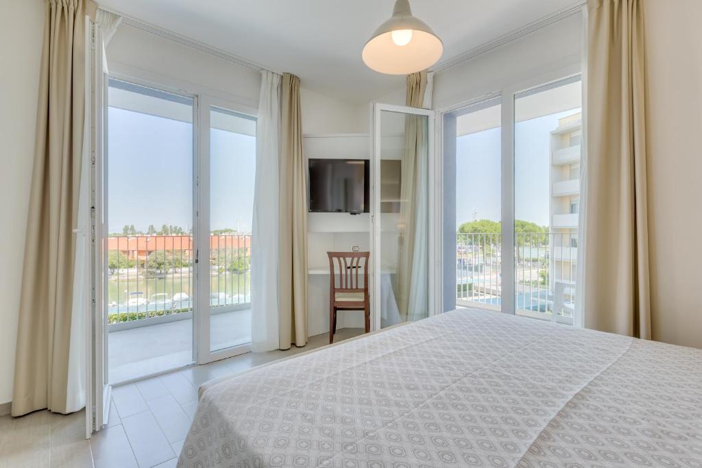 ein Schlafzimmer mit einem großen Bett und einem Balkon in der Unterkunft Apartaments Suites Ambassador in Caorle