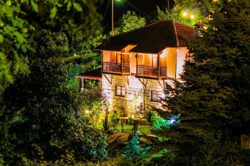 uma casa é iluminada à noite com luzes de Natal em Mylos em Arkochórion