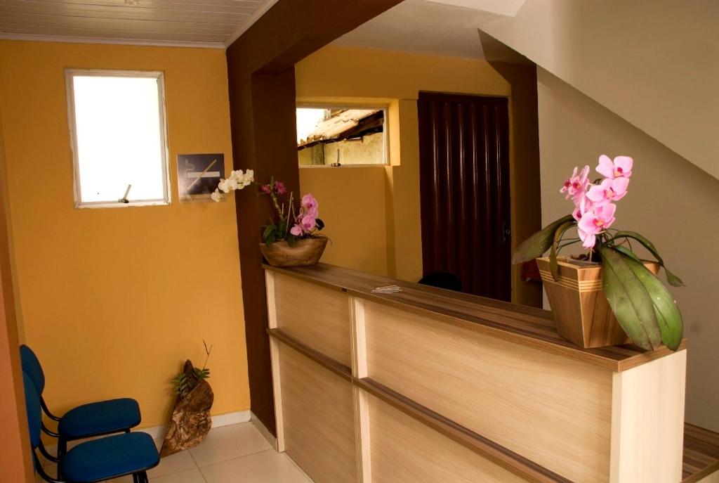 um quarto com um balcão com flores em Orquídea Hotel em Viçosa