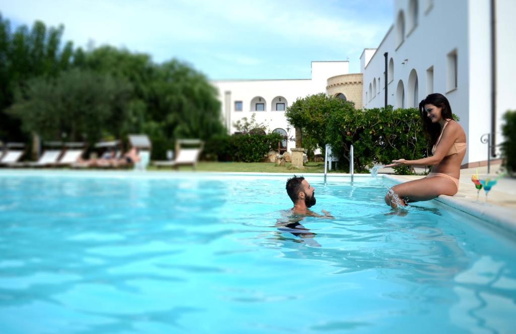 Due donne che giocano con un bambino in una piscina di Hotel Montecallini - Adult Only 14 a Patù