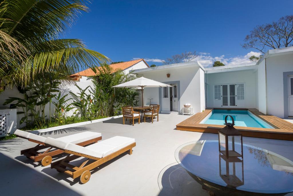 a backyard with a swimming pool and a house at Pousada Casa de Paraty in Paraty