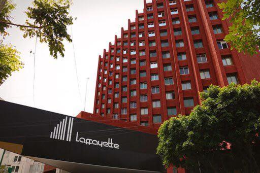 ein großes rotes Gebäude mit einem Schild davor in der Unterkunft Hotel Laffayette Ejecutivo in Guadalajara