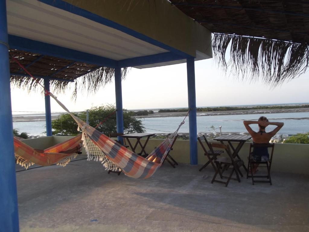 a woman sitting at a table in a hammock at Pousada Dona Fátima in Macau