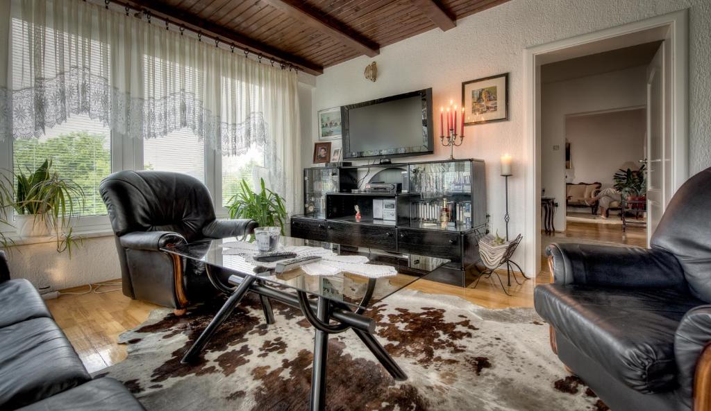 uma sala de estar com uma mesa e cadeiras e uma televisão em Mott Residence em Tuzla