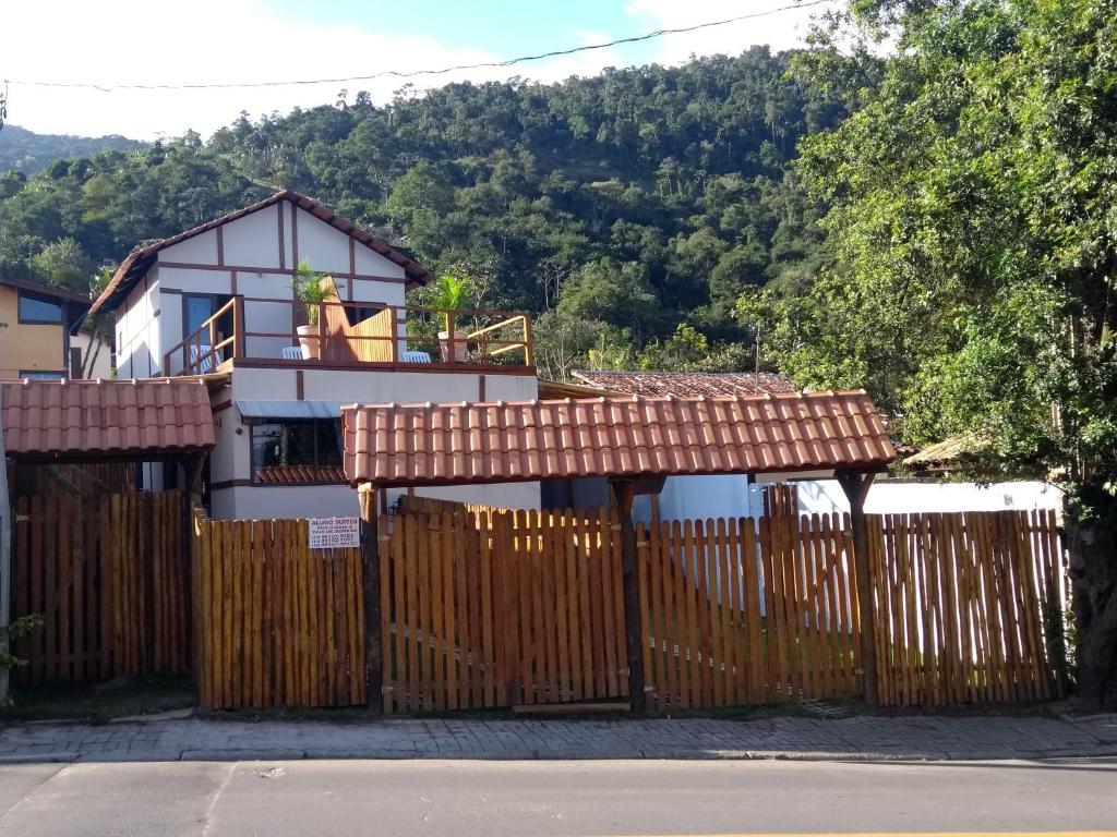 una casa con una valla de madera delante de ella en Casa Linda Ilhabela, en Ilhabela