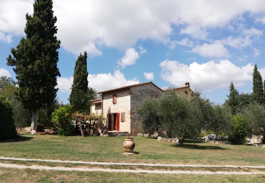 a house with a vase in front of a yard at Nel Chianti lungo la Francigena in Colle Val D'Elsa