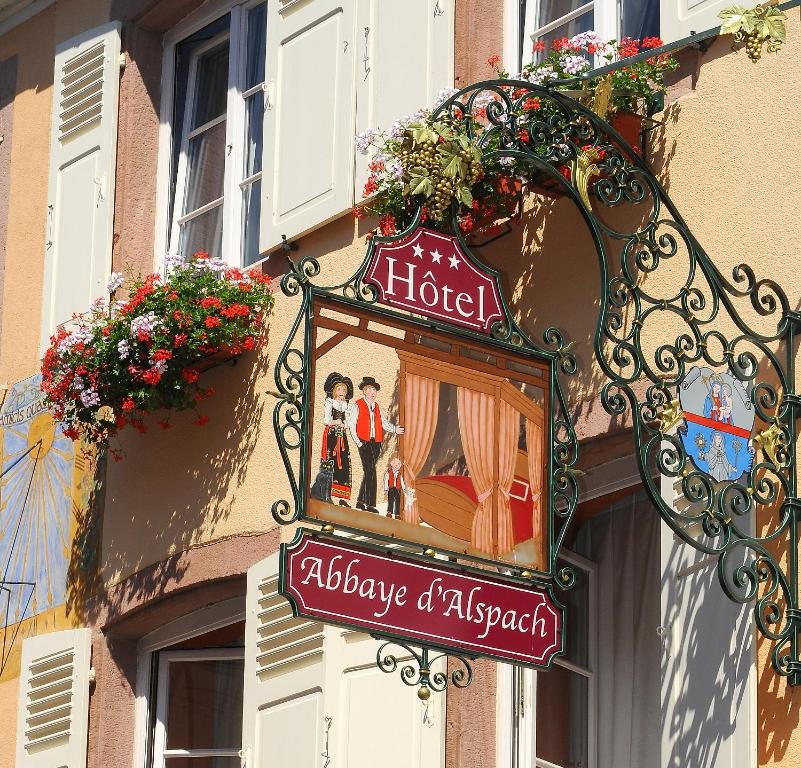 a sign for a hotel on the side of a building at L'Abbaye d'Alspach in Kientzheim