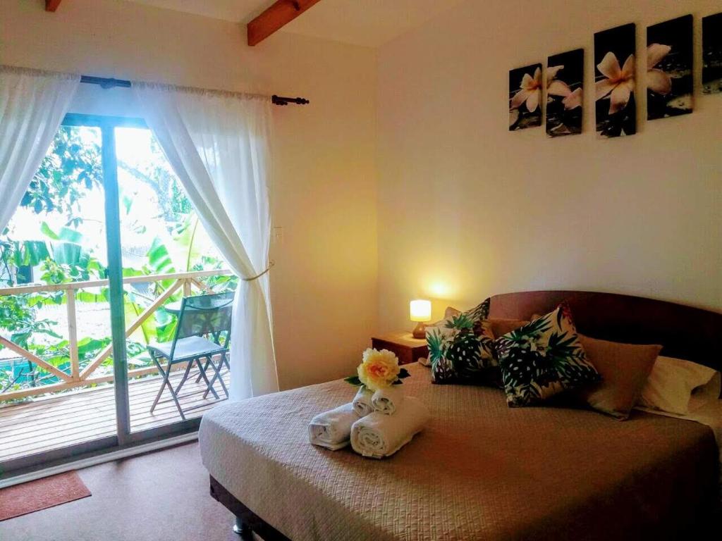 a bedroom with a bed with flowers and a window at Cabañas Te Maori in Hanga Roa