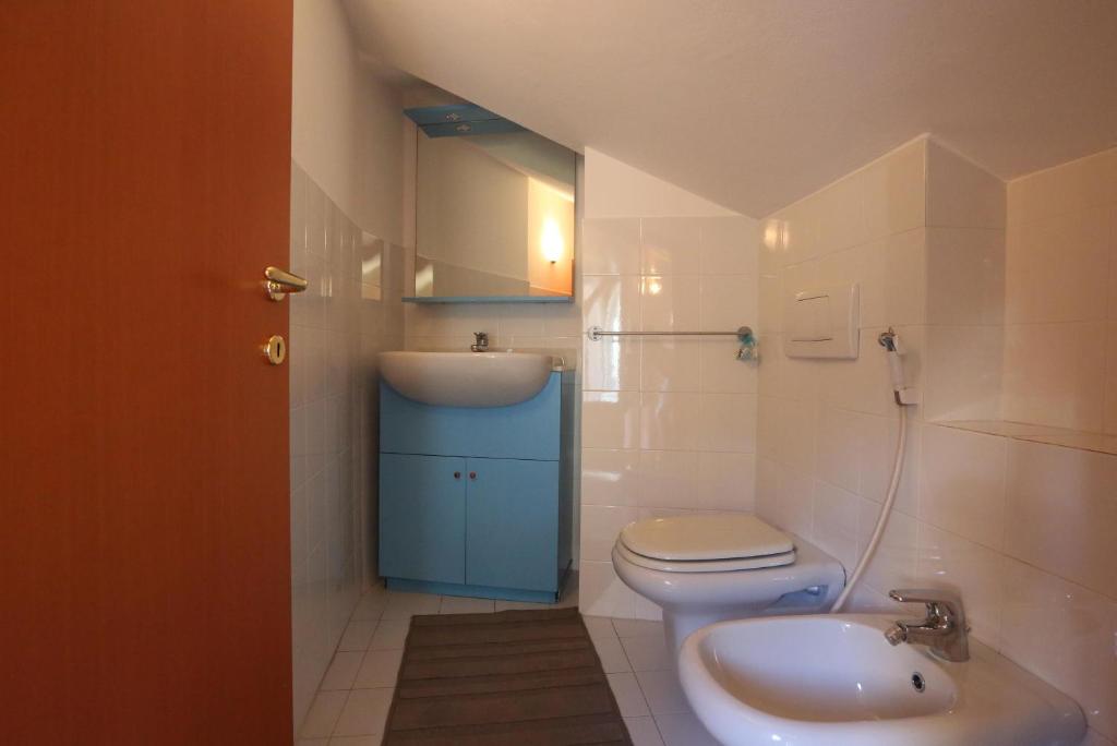 a bathroom with a toilet and a sink at Appartamento Vandero in Alba