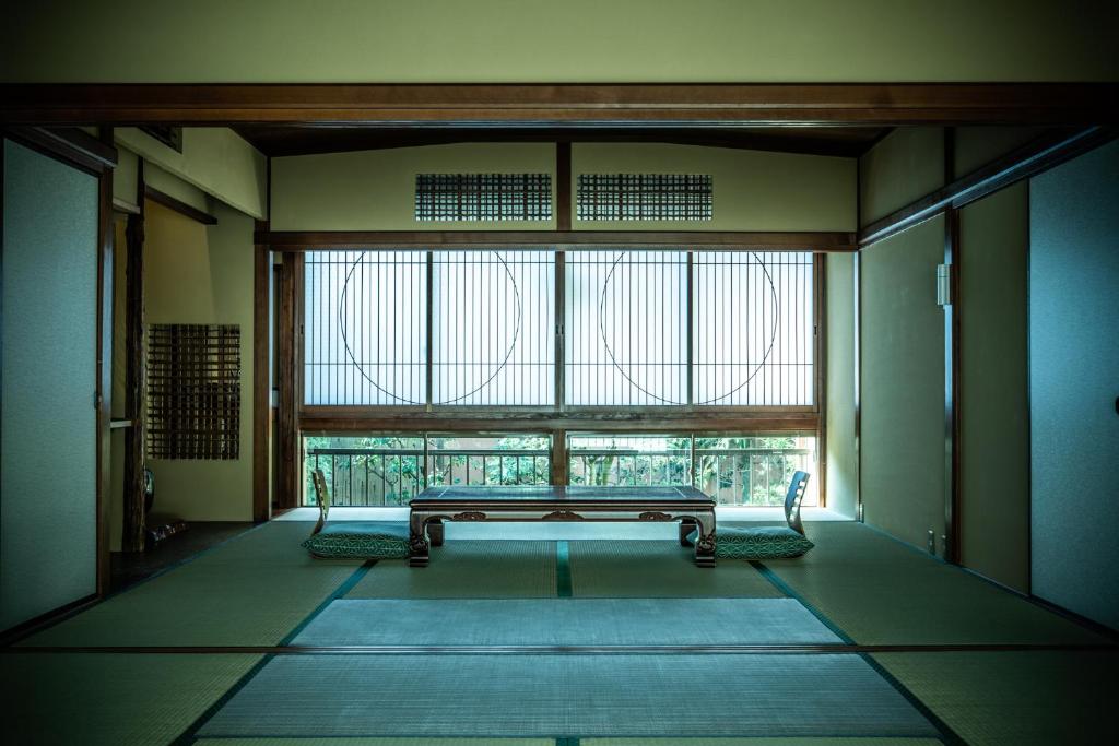 a room with a bench in front of a large window at Yamadaya Ryokan in Kyoto