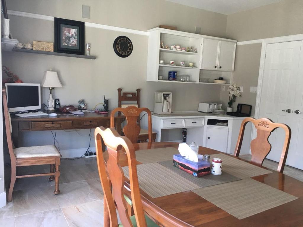 a kitchen with a table and chairs and a desk at Seaview White House in Stratford