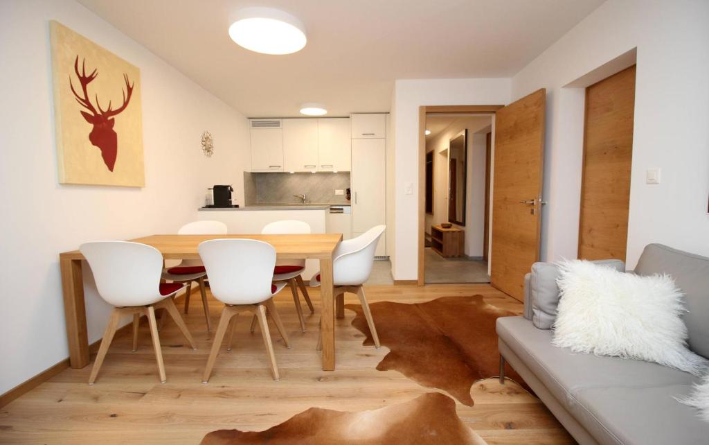 a kitchen and dining room with a table and chairs at Au Réduit 412 in St. Moritz