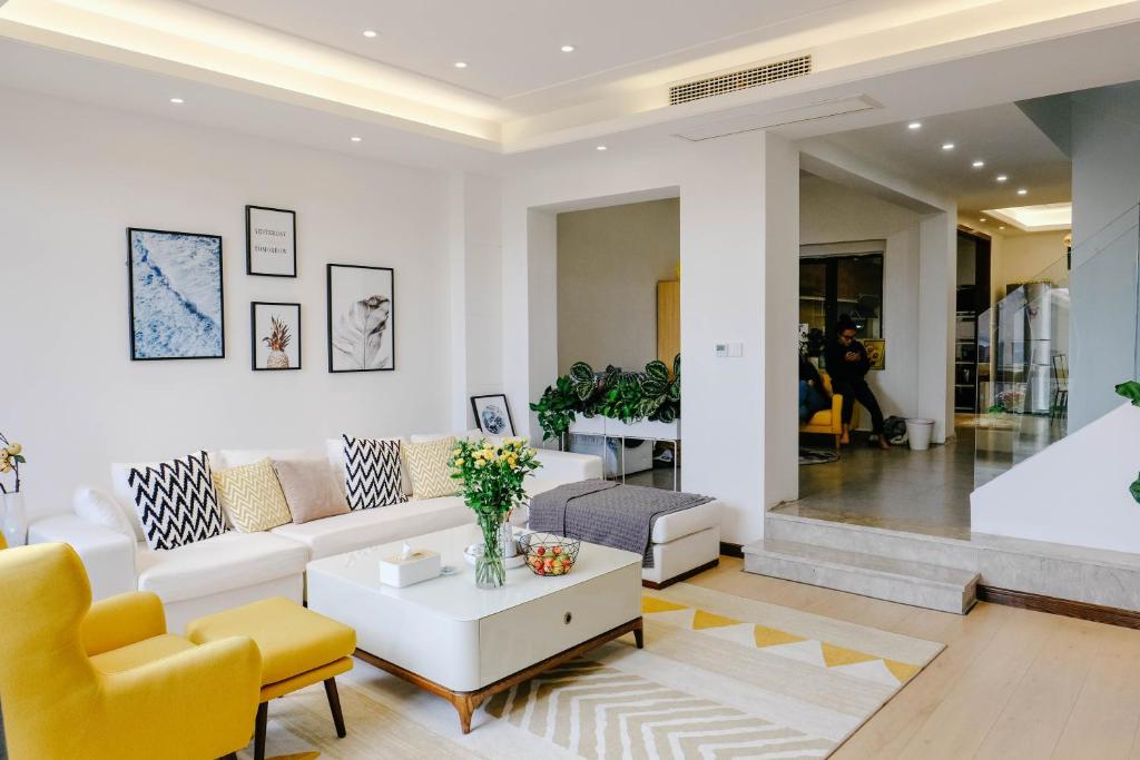 sala de estar con sofá blanco y sillas amarillas en Dali lila's house Seaview Guesthouse en Dali