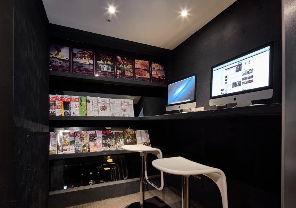 a restaurant with a bar with two stools and a tv at Via Loft Hotel in Taipei