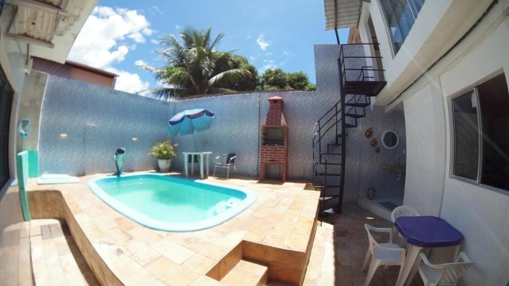 a swimming pool in a backyard with a building at Pousada Sandra Convenções in Recife