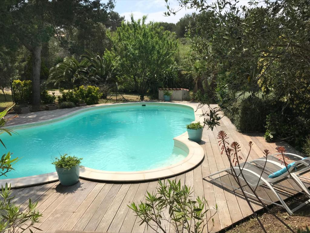 einen großen Pool auf einer Holzterrasse in der Unterkunft Rez de jardin villa Presqu'ile de Giens in Hyères