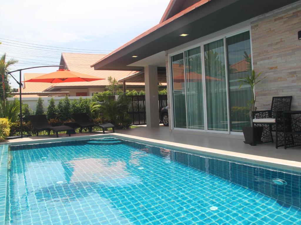 a swimming pool in front of a house at The Ville Pool Villa Jomtien A23 in Jomtien Beach
