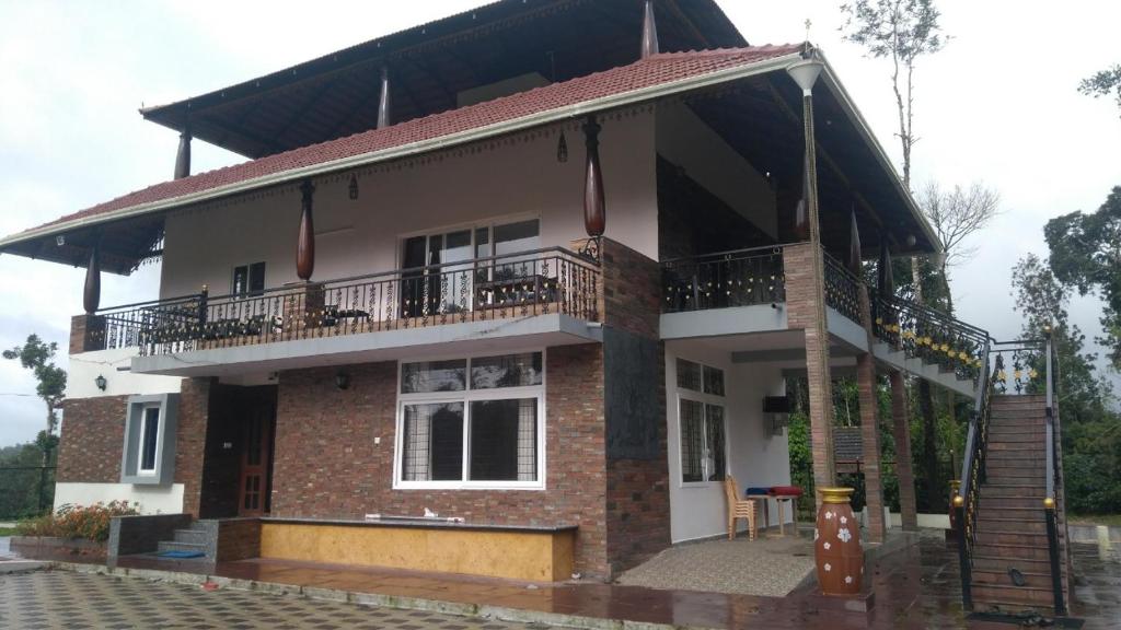 a house with a balcony on top of it at Lake Trail Homestay Coorg in Madikeri