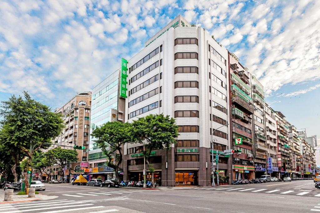 un edificio blanco alto con un letrero verde. en Green World Linsen en Taipéi