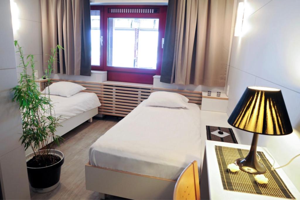 Habitación con 2 camas y mesa con lámpara. en Totalenergies Frit Autentic Habay-la-Neuve, en Habay-la-Neuve