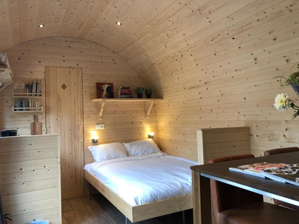 1 dormitorio pequeño con 1 cama en una habitación de madera en Little Lighthouse Texel, en De Cocksdorp
